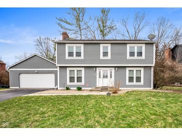 Two-story home boasts gray siding, a well-manicured lawn, and an attached two-car garage at 3029 Oberlin Ct, Indianapolis, IN 46268