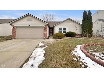 Charming single-story home with a well-maintained lawn and attached garage on a partly cloudy day at 307 Beacon Point Ln, Fortville, IN 46040