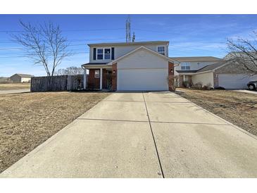 Charming two-story home with a two-car garage and a long driveway and manicured lawn at 3951 Narrowleaf Ct, Indianapolis, IN 46235