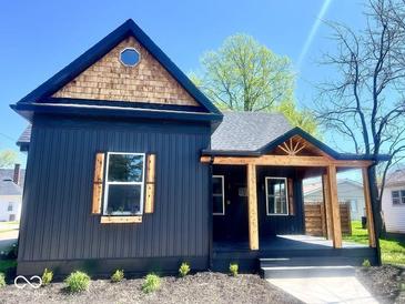 Charming home featuring dark siding, wooden accents, a covered porch, and a uniquely shaped window at 511 N Clark St, Lebanon, IN 46052
