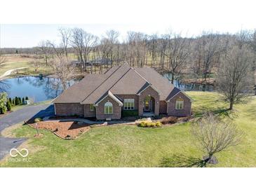 Aerial view of a stunning brick home with a pond, mature trees, and beautifully landscaped grounds at 563 E Greencastle Rd, Mooresville, IN 46158