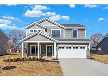 Charming two-story home featuring a covered porch, a two-car garage, and a well-lit exterior at 7152 Jackson Dr, Cumberland, IN 46229