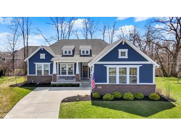 Charming blue, single-Gathering home with brick accents, manicured lawn and three dormer windows at 11072 Song Creek Ct, Fishers, IN 46040