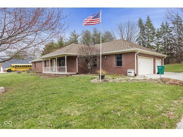 Charming brick home with an American flag, manicured lawn, and attached two-car garage at 12129 N Cedarview Dr, Mooresville, IN 46158