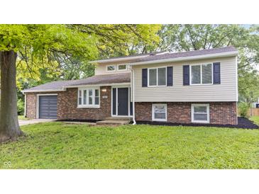 Charming two-story home featuring a brick and siding facade, well-maintained lawn and an attached garage at 1641 Whistler Terrace, Indianapolis, IN 46229