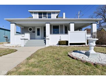 Charming home with a covered front porch, white painted brick facade, and landscaped front yard at 32 E Main St, Mooresville, IN 46158