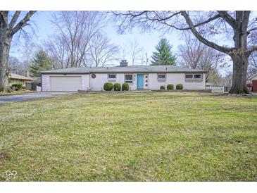 Charming ranch-style home featuring a manicured lawn, attached garage and eye-catching light blue front door at 5415 Wallace Ave, Indianapolis, IN 46220