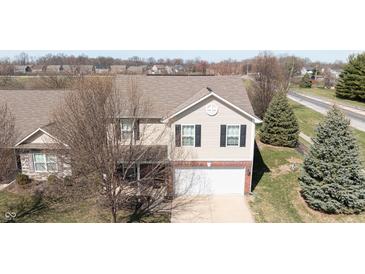 Two-story home with light beige siding, black shutters, and a brick front, plus an attached garage at 5944 Edelle Dr, Indianapolis, IN 46237