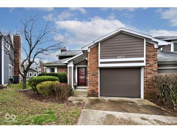 Charming home with a brick and vinyl exterior, featuring an attached garage and manicured landscaping at 8077 Foxchase Dr, Indianapolis, IN 46256