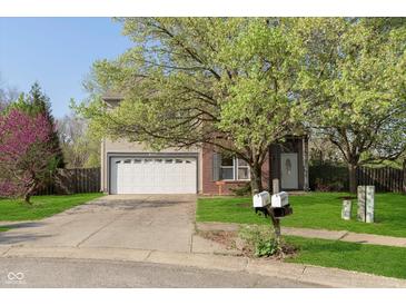 Inviting home with a two-car garage, lush lawn, and mature trees in a desirable neighborhood at 9011 Harrison Run Dr, Indianapolis, IN 46256