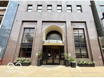 Building entrance featuring a glass door entry, well-maintained landscaping and planters at 110 E Washington St # 802, Indianapolis, IN 46204