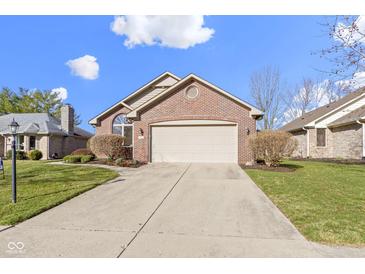 Charming brick home featuring an attached two-car garage and manicured landscaping under a sunny sky at 153 Monticello Ct, Noblesville, IN 46060