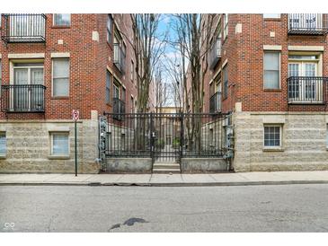 Apartment building with iron gates and a landscaped courtyard; perfect for urban living at 226 N Cleveland St # 226E, Indianapolis, IN 46204