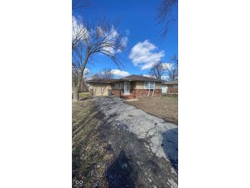 Charming single-story home featuring a brick facade, attached garage, and well-maintained front yard at 3830 Aloda St, Indianapolis, IN 46203