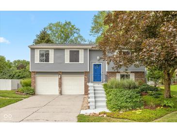 Charming gray split-level home with a blue front door and a two-car garage at 9462 Bent Brook Dr, Indianapolis, IN 46250