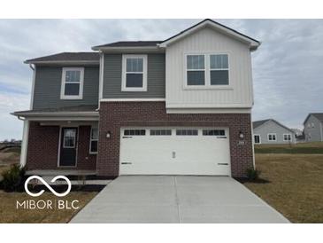 Two-story home with gray siding and brick accents, featuring a two-car garage and well-maintained lawn at 2109 Boxwood Dr, Greenfield, IN 46140