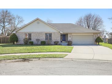 Charming ranch-style home with a brick facade, attached garage, and manicured front lawn on a sunny day at 2231 Reston Ln, Columbus, IN 47203