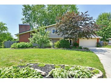 Charming home with a brick chimney and beautiful landscaping, offering curb appeal at 2700 Yellowwood Ct, Columbus, IN 47203