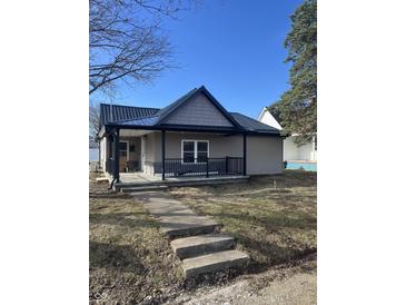 Charming home featuring a dark metal roof, cozy front porch with black railings, and neutral siding at 354 Bloomingdale Rd, Montezuma, IN 47862