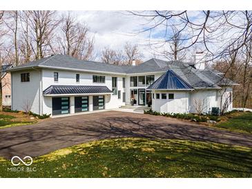 Elegant home featuring a black metal roof, a three-car garage and an extra turret at 395 Breakwater Dr, Fishers, IN 46037