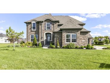 Stunning two-story brick home boasting meticulous landscaping, manicured lawn, and elegant architectural details at 4255 Kettering Dr, Zionsville, IN 46077