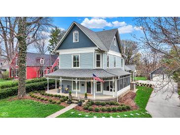Charming two-story home with a large porch, beautiful landscaping, and lush green grass at 450 W Ash St, Zionsville, IN 46077