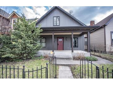 Charming home featuring a welcoming front porch and nicely landscaped yard at 615 E Morris St, Indianapolis, IN 46203