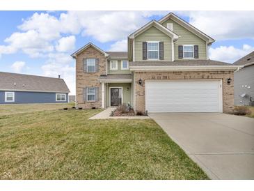 Inviting two-story home featuring a two-car garage, green siding and brick accents at 6180 N Rosewood Dr, McCordsville, IN 46055