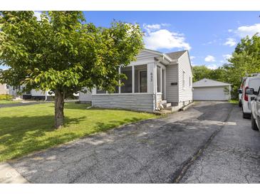 Charming home with a screened-in porch, paved driveway, and a detached garage at 633 Fletcher Ln, Beech Grove, IN 46107