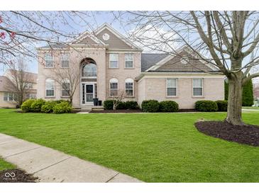 Attractive two-story home with brick facade, manicured lawn and mature landscaping at 8253 Belcrest Ct, Indianapolis, IN 46256