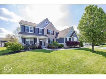 Beautiful two-story home with a manicured lawn, brick, and blue painted siding at 10027 Landis Blvd, Fishers, IN 46040