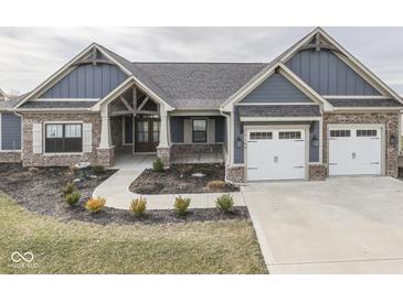 Charming craftsman style home with brick and siding, featuring a three-car garage and professionally landscaped yard at 2145 W Bedrock Ln, Greenfield, IN 46140