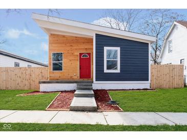 Modern home featuring a unique angular roof, wood and navy siding, and a bright red front door at 242 N Tacoma Ave, Indianapolis, IN 46201
