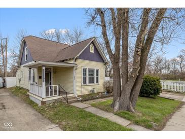 Charming yellow two-story home with purple accents and a well-maintained front yard on a sunny day at 602 Prospect St, Indianapolis, IN 46203