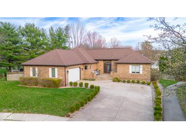 Charming brick home with a well-manicured lawn, inviting entrance, and a spacious driveway at 6043 Acorn Dr, Columbus, IN 47201