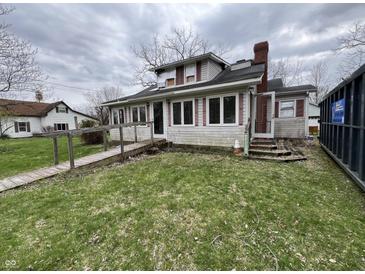 Two-story home with a ramp leading to the front door, red shutters, and a chimney against a cloudy sky at 805 W 3Rd St, Alexandria, IN 46001