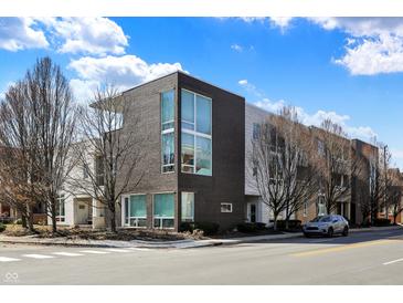 Modern townhome complex featuring a blend of dark brick and white siding, highlighted by expansive windows and professional landscaping at 932 Broadway St # 15, Indianapolis, IN 46202