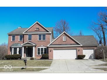 Charming two-story brick home with attached two car garage and well-manicured landscaping at 14573 Waverly Dr, Carmel, IN 46033