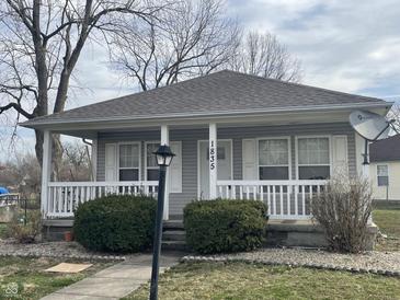 Charming home featuring a cozy front porch, gray siding, and a well-maintained landscaped yard at 1835 Carpenter Cir, Indianapolis, IN 46203