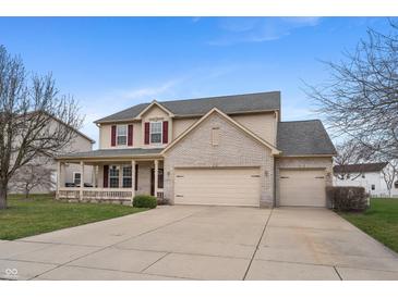 Inviting two-story home with a brick-accented facade, attached three-car garage, and a charming covered porch at 1975 Westminster Pl, Columbus, IN 47201