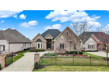 Charming brick home featuring a meticulously landscaped front yard and a private gated entrance at 4703 River Ridge Dr, Indianapolis, IN 46240
