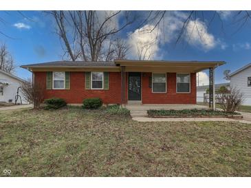 Inviting single-story brick home featuring a cozy covered front porch, green shutters and landscaped garden at 4812 Eastgate Dr, Columbus, IN 47203