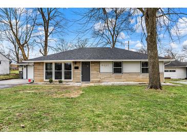 Charming single-story home with a stone facade and well-manicured front lawn at 5887 Meadowlark Dr, Indianapolis, IN 46226