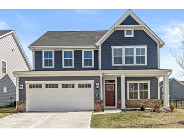 Charming two-story home featuring a two-car garage and attractive blue siding, set against a bright sky at 629 Washington St, Fortville, IN 46040