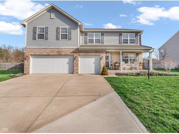 Charming two-story home with a two-car garage, well-manicured lawn, and inviting front porch seating at 6746 Wilmot Ln, Avon, IN 46123