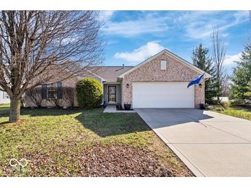 Charming brick home with a two-car garage and long driveway on a sunny day at 7260 Blue Ridge Dr, Noblesville, IN 46062