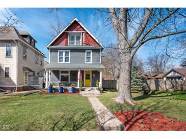 Charming two-story home with a well-manicured lawn and inviting yellow door at 774 Woodruff Pl E Dr, Indianapolis, IN 46201