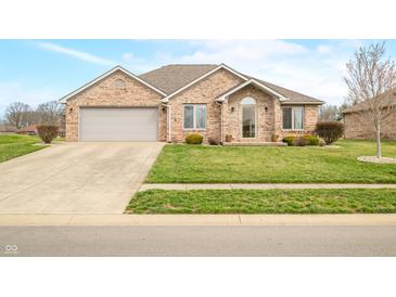 Charming brick home featuring a two-car garage and beautifully landscaped front yard at 1120 Constitution Dr, Edinburgh, IN 46124