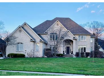 Elegant two-story brick home featuring a lush lawn, well-maintained landscaping, and an inviting entrance at 11967 Windpointe Pass, Carmel, IN 46033
