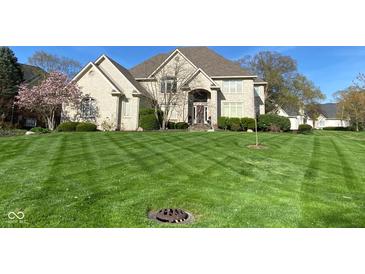 Beautiful brick home showcasing a well-manicured lawn and lush landscaping at 11967 Windpointe Pass, Carmel, IN 46033
